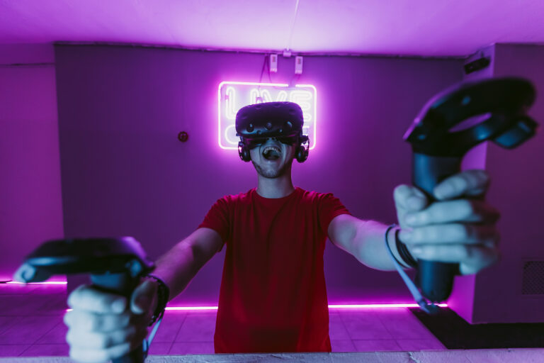 VR E-Sports. The guy is playing an online shooter in the game neon room. High quality photo